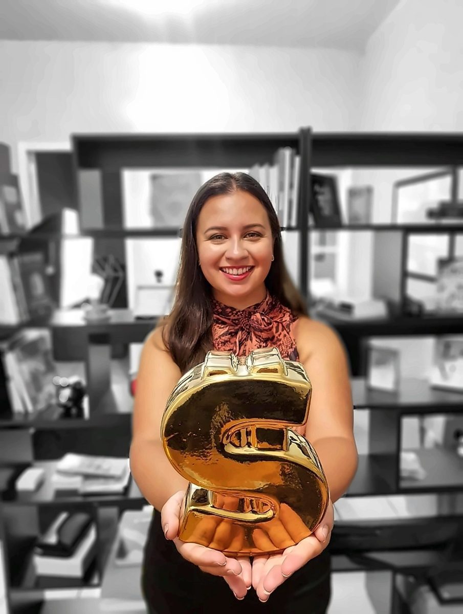 Janile Soares, economista, segurando um cifrão dourado